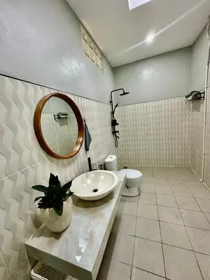 a bathroom with a sink and a mirror and a toilet at New Mekar Jaya Hotel in Legian