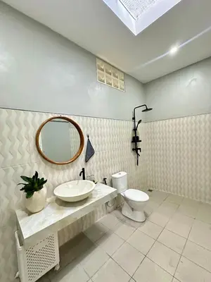 a bathroom with a sink and a toilet and a mirror at New Mekar Jaya Hotel in Legian