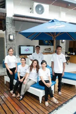 a group of people sitting on a bench under an umbrella at Focus on 4 in Seminyak