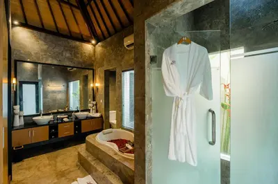 a bathroom with a robe hanging on a shower door at Focus on 4 in Seminyak