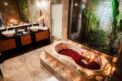 a bathroom with a large tub with candles in it at Focus on 4 in Seminyak
