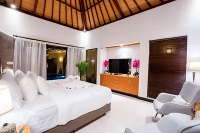 a bedroom with a large bed and two chairs at Focus on 4 in Seminyak