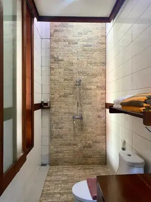 a bathroom with a shower with a toilet and a sink at Meilds Property Segara Kuta in Kuta