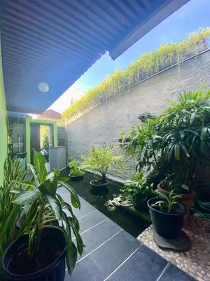 a patio with potted plants and a brick wall at Meilds Property Segara Kuta in Kuta