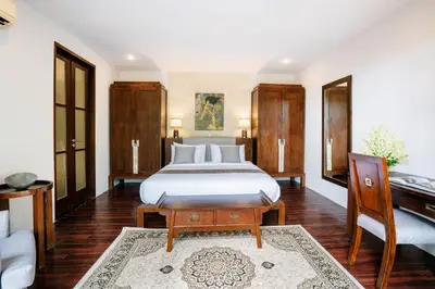 a bedroom with a bed and a desk and a piano at Villa Pulung Jimbaran by Nakula in Jimbaran