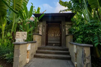a entrance to a building with a wooden door at Villa Pulung Jimbaran by Nakula in Jimbaran