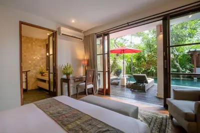 a bedroom with a bed and a patio with a pool at Villa Pulung Jimbaran by Nakula in Jimbaran