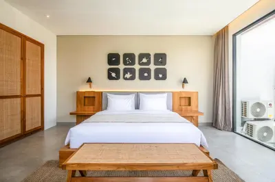a bedroom with a white bed and a table at Brand new Luxury 5 br villa 200m to Brawah Beach in Canggu