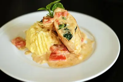 a white plate of food with a piece of fish and pasta at Bali Chaya Hotel Legian in Legian