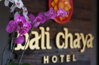 a sign that says callaway hotel with purple flowers at Bali Chaya Hotel Legian in Legian