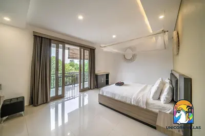 a bedroom with a bed and a balcony at Rumah Senang - by Unicorn Villas Bali in Seminyak