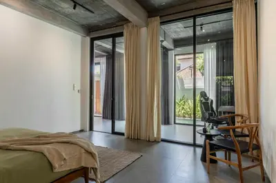 a bedroom with a bed and sliding glass doors at Sasa's Villa Seminyak in Seminyak