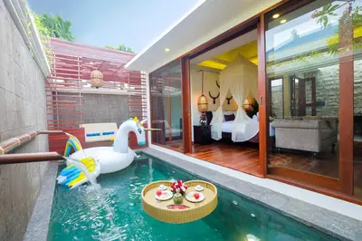 a room with a pool with a swan and a bedroom at Villa Bougainville in Seminyak