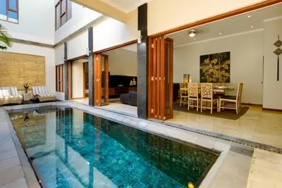 an indoor swimming pool in a house with a dining room at Super 4 Bed, Sleeps 8, Just 300m walk from Beach in Legian