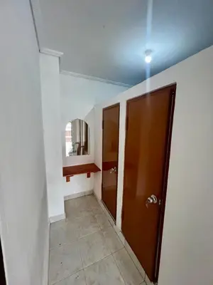 a hallway with a bathroom with a mirror and a door at Rodin Bali Hostel in Seminyak