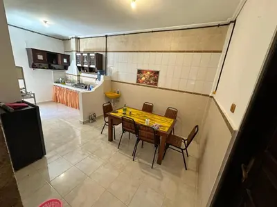 a kitchen and dining room with a wooden table and chairs at Rodin Bali Hostel in Seminyak