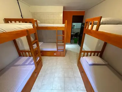 a room with three bunk beds and a hallway at Rodin Bali Hostel in Seminyak