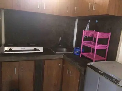 a kitchen with a pink chair and a sink at simple apartment 2 in Seminyak