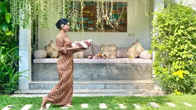 a woman in a dress standing in front of a couch at Villa Malou in Seminyak