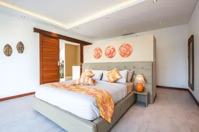 a bedroom with a large white bed with orange pillows at Stunning 6 Bedroom Villa Only 400m to the Beach in Canggu