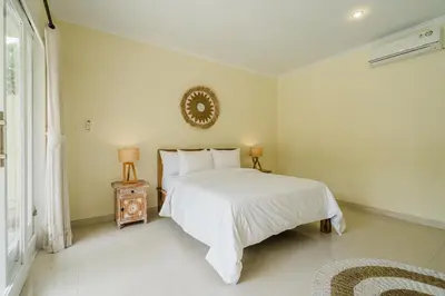 a white bedroom with a bed and a window at Villa Melati - Seminyak in Seminyak