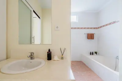 a bathroom with a sink and a tub and a mirror at Villa Melati - Seminyak in Seminyak