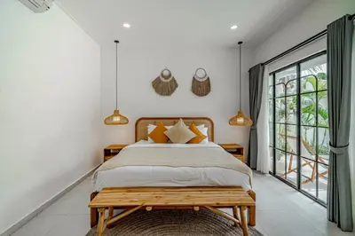 a bedroom with a bed and a large window at Villa Lemone 3 by Bali Villa Solutions in Seminyak