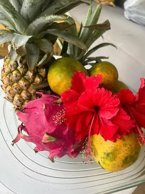 a bowl of fruit with a pineapple and a red flower at Villa Lemone 3 by Bali Villa Solutions in Seminyak