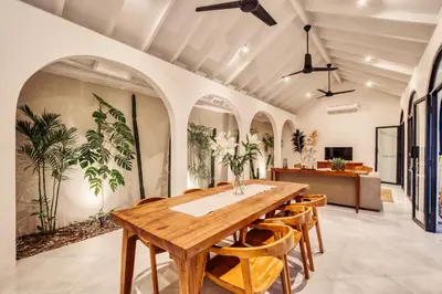 a dining room with a wooden table and chairs at Villa Arca Seminyak by Santi Management in Seminyak