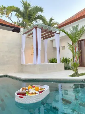 a pool with a bowl of food in the water at Villa Akmali Umalas 2BR with Private Pool & Jacuzzi in Canggu
