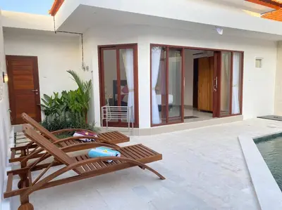 a patio with a chair and a swimming pool at Villa Akmali Umalas 2BR with Private Pool & Jacuzzi in Canggu