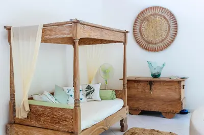 a bedroom with a wooden canopy bed with pillows at Villa Casabola - Seminyak in Seminyak