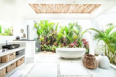 a bathroom with a large tub and plants at Modern 4 BR Villa 400m to the Beach in Canggu in Canggu