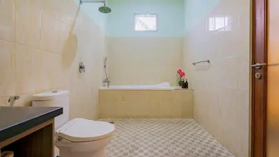 a bathroom with a toilet and a bath tub at Villa Harmony - Seminyak in Seminyak