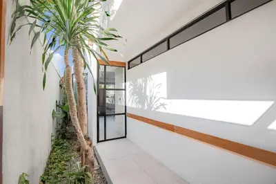 a hallway with a palm tree in a house at Town House CAMY in Seminyak