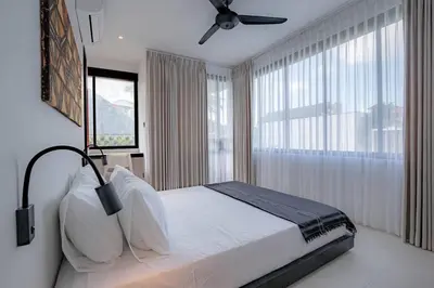 a bedroom with a bed and a ceiling fan at Town House CAMY in Seminyak