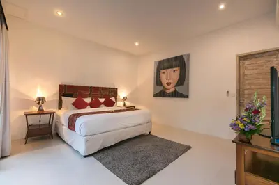 a bedroom with a bed and a painting on the wall at Villa Briana Seminyak by Villas R Us in Seminyak