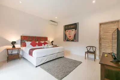 a bedroom with a bed and a painting on the wall at Villa Briana Seminyak by Villas R Us in Seminyak