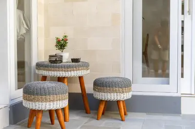 a table and two stools sitting on a porch at Villa Della One in Seminyak