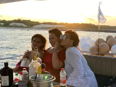 three people sitting at a table on a boat at Private Yacht Bali to Nusa Penida in Ujung