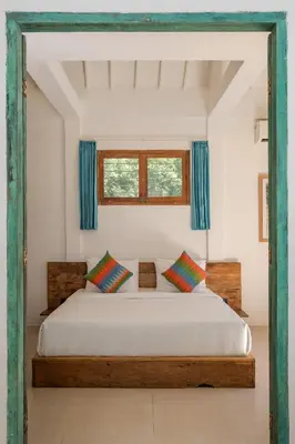 a bedroom with a large bed with blue curtains at 2 BDR villa, walking distance to Seminyak beach. in Seminyak