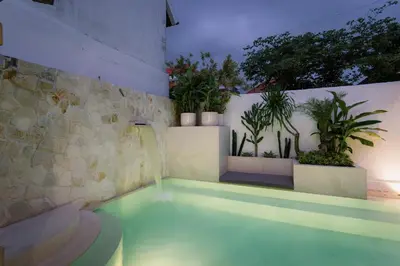 a swimming pool in a house with plants at Villa Batu Putih Seminyak in Seminyak