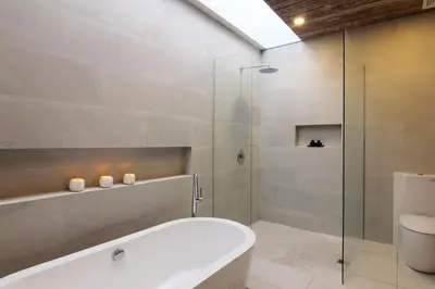 a bathroom with a tub and a glass shower at Abivilla in Seminyak