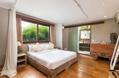 a bedroom with a large white bed and a window at Villa Yoga by Villa Finder in Seminyak
