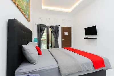a bedroom with a large bed and a television at RedDoorz at Lotus House Seminyak in Seminyak
