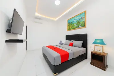 a bedroom with a bed and a flat screen tv at RedDoorz at Lotus House Seminyak in Seminyak