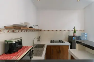 a small kitchen with a sink and a microwave at Villa Skyler Seminyak in Seminyak