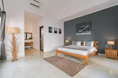 a bedroom with a king sized bed and a desk at Villa Skyler Seminyak in Seminyak