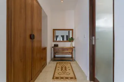 a hallway with a door and a mirror and a rug at Villa Skyler Seminyak in Seminyak