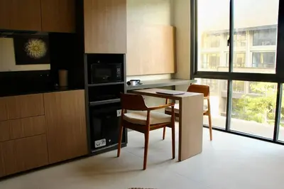 a kitchen with a table and two chairs and a microwave at Cozy Minimalist Apartment Lavaya N511 in Nusa Dua